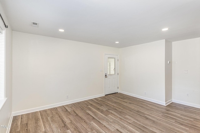 empty room with recessed lighting, light wood-style floors, and baseboards