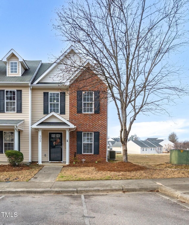 view of front of property featuring brick siding and cooling unit