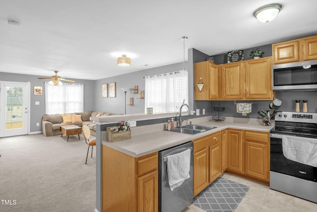 kitchen featuring a healthy amount of sunlight, appliances with stainless steel finishes, light countertops, and a sink