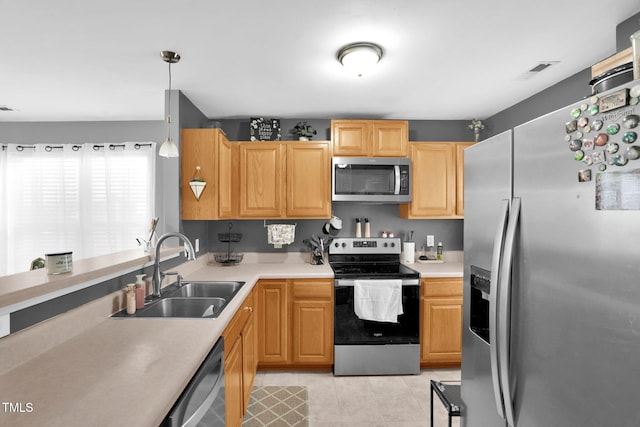 kitchen featuring light tile patterned floors, stainless steel appliances, light countertops, hanging light fixtures, and a sink