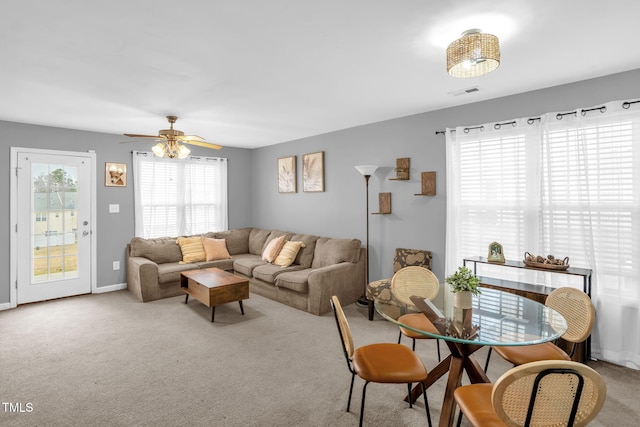 living room with baseboards, carpet flooring, visible vents, and a ceiling fan