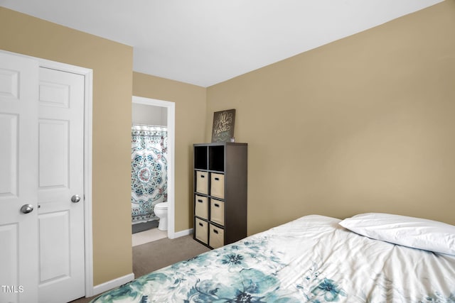 bedroom with carpet floors, baseboards, and ensuite bathroom