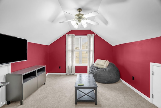 sitting room with carpet, vaulted ceiling, baseboards, and ceiling fan