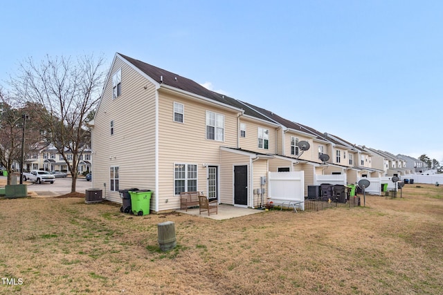 rear view of property featuring a residential view, a lawn, and a patio