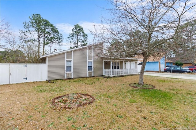 view of front of property with covered porch, a front lawn, and fence