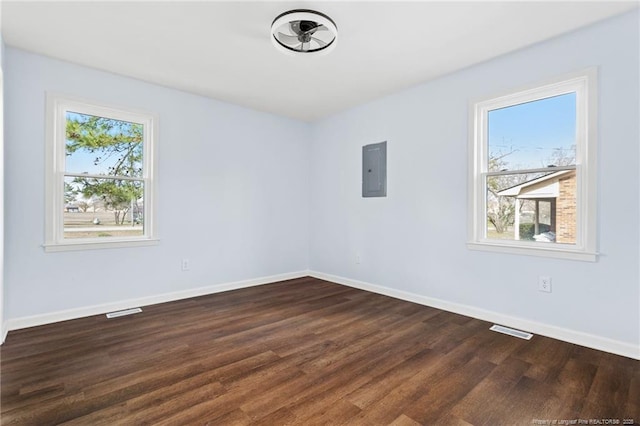 spare room featuring baseboards, electric panel, visible vents, and a wealth of natural light