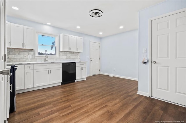 kitchen with dark wood finished floors, light countertops, dishwasher, and a sink