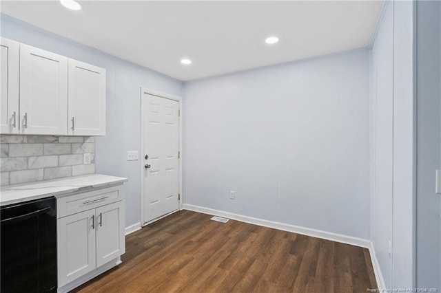 kitchen featuring white cabinetry, backsplash, light stone countertops, dishwasher, and dark wood finished floors