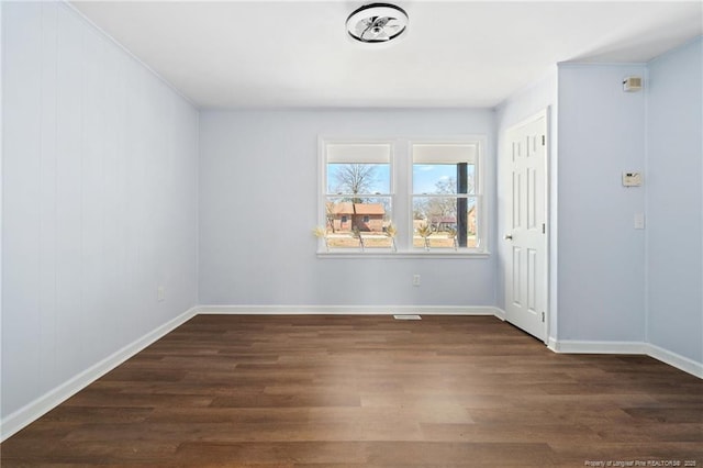 unfurnished room featuring dark wood-style floors and baseboards