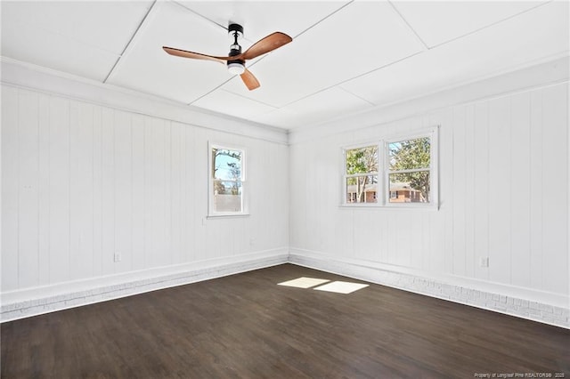 empty room with dark wood-style floors, ceiling fan, baseboards, and a healthy amount of sunlight