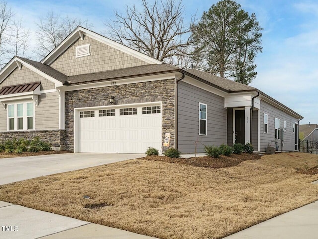 craftsman house with concrete driveway, an attached garage, and stone siding