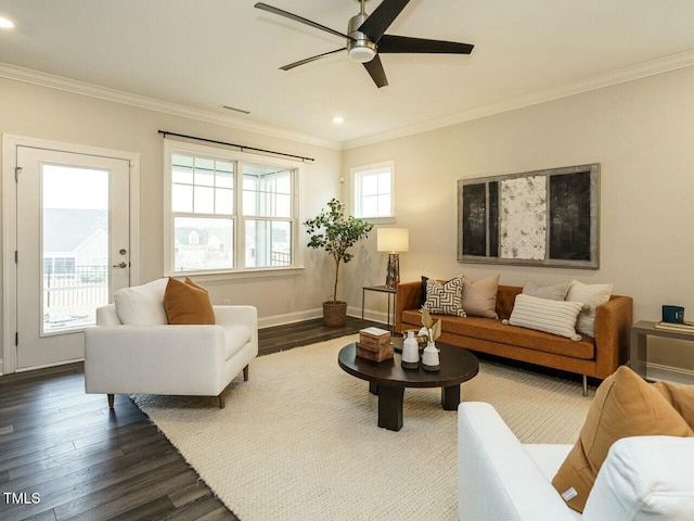 living room with ornamental molding, a ceiling fan, and dark wood-style flooring