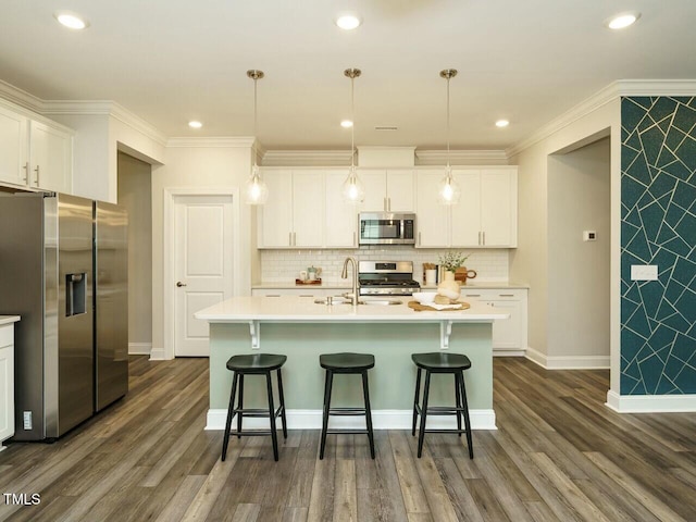 kitchen featuring dark wood finished floors, a sink, stainless steel appliances, light countertops, and a kitchen breakfast bar