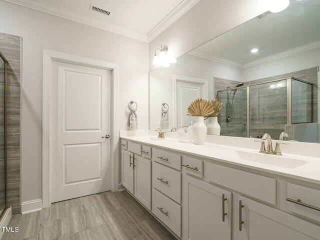 full bathroom featuring a shower stall, ornamental molding, visible vents, and a sink