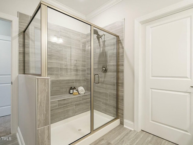 bathroom with crown molding, baseboards, and a stall shower