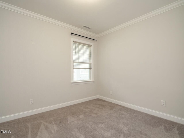 spare room featuring baseboards, carpet floors, visible vents, and ornamental molding