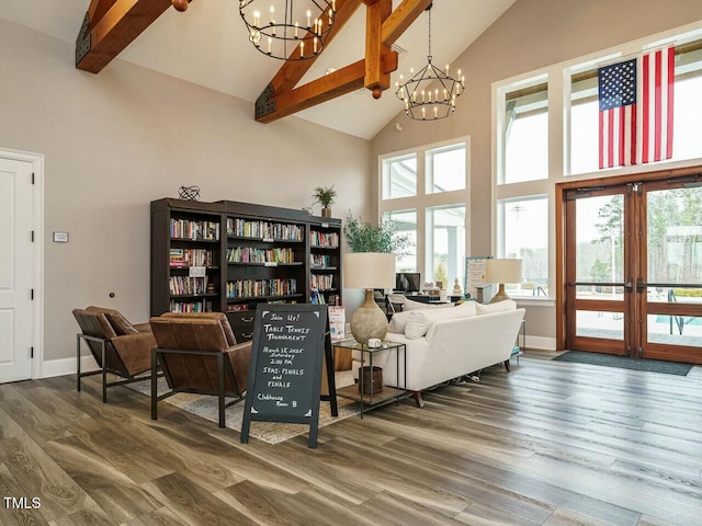 sitting room featuring french doors, a notable chandelier, wood finished floors, and high vaulted ceiling