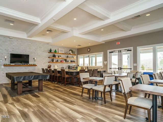 dining space with beam ceiling, visible vents, and a community bar