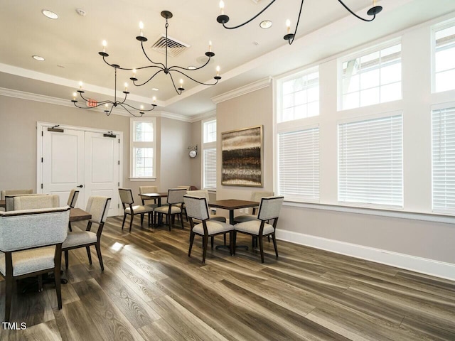 dining room with visible vents, baseboards, a tray ceiling, ornamental molding, and dark wood-style floors