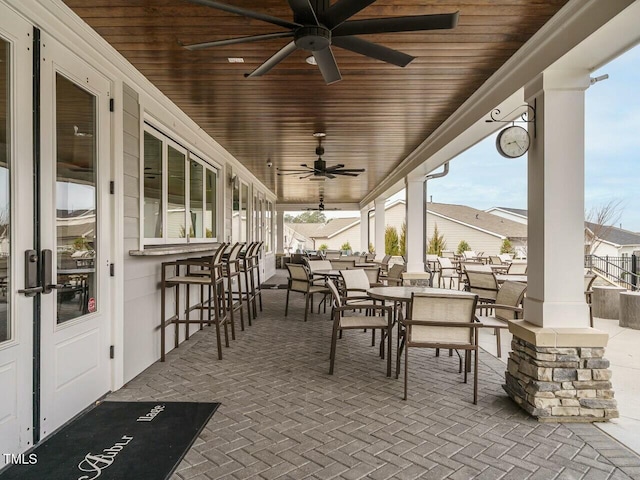 view of patio featuring outdoor dry bar, outdoor dining space, and a ceiling fan