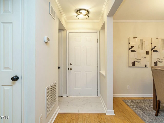 entrance foyer featuring baseboards, visible vents, and ornamental molding