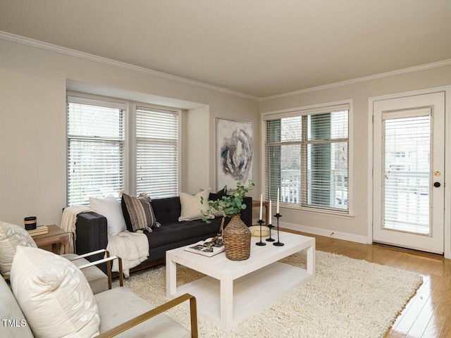 living room with crown molding, light wood-style flooring, and baseboards