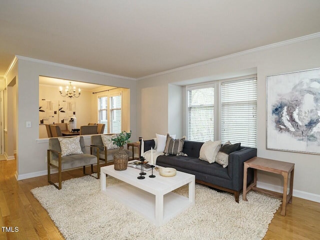 living area featuring light wood-type flooring, baseboards, a chandelier, and crown molding