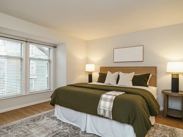 bedroom featuring wood finished floors and baseboards