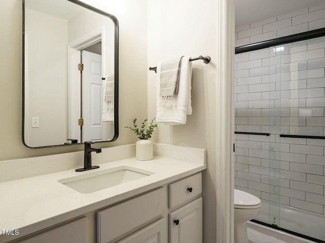 full bathroom with toilet, a stall shower, and vanity