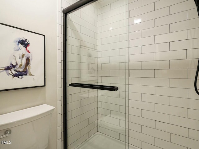 bathroom featuring toilet and a stall shower