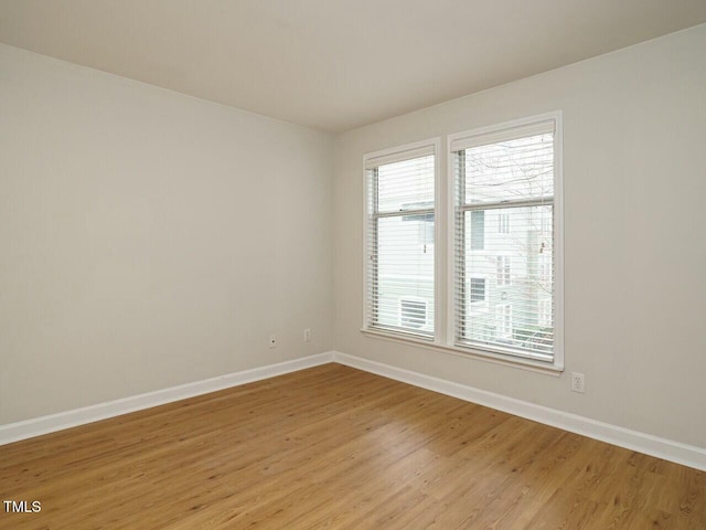 empty room with light wood-style floors and baseboards