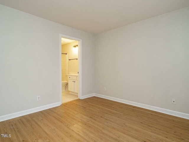 unfurnished room with baseboards and light wood-style floors