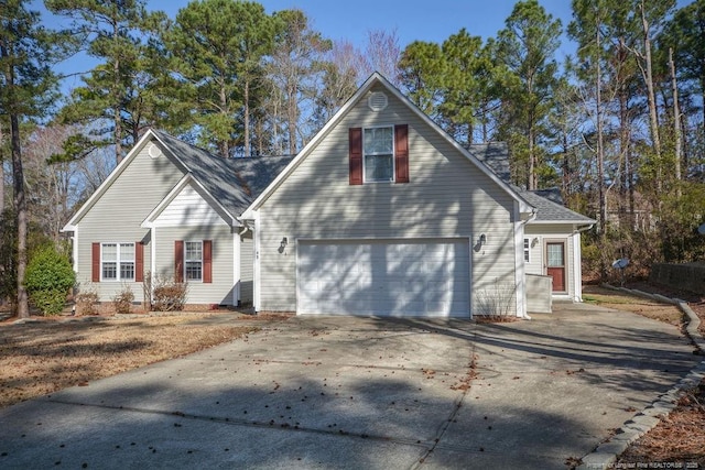 view of front of property featuring concrete driveway and roof with shingles