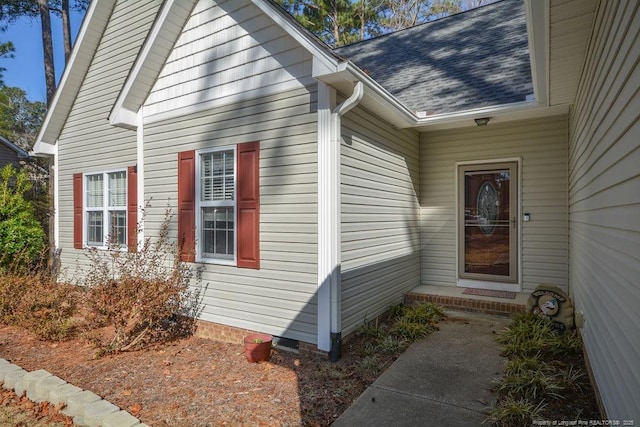 property entrance featuring roof with shingles