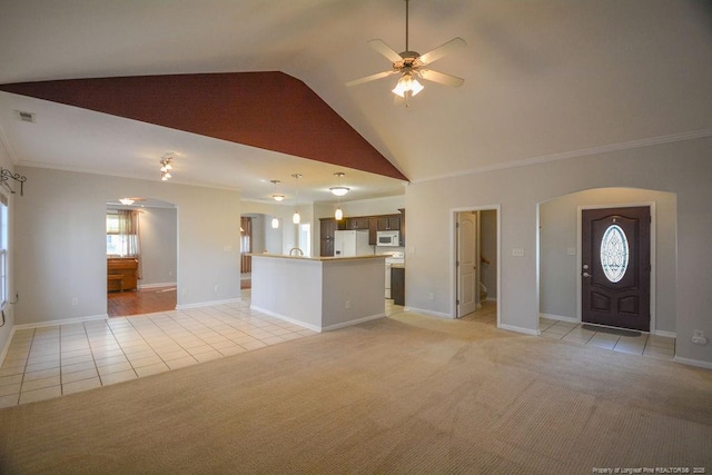 unfurnished living room with light carpet, visible vents, arched walkways, ceiling fan, and light tile patterned flooring