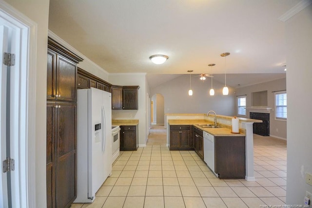 kitchen with arched walkways, white appliances, a sink, and dark brown cabinets