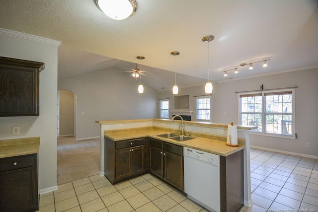 kitchen featuring light tile patterned floors, arched walkways, a sink, open floor plan, and dishwasher