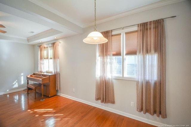 spare room featuring ornamental molding, a ceiling fan, baseboards, and wood finished floors