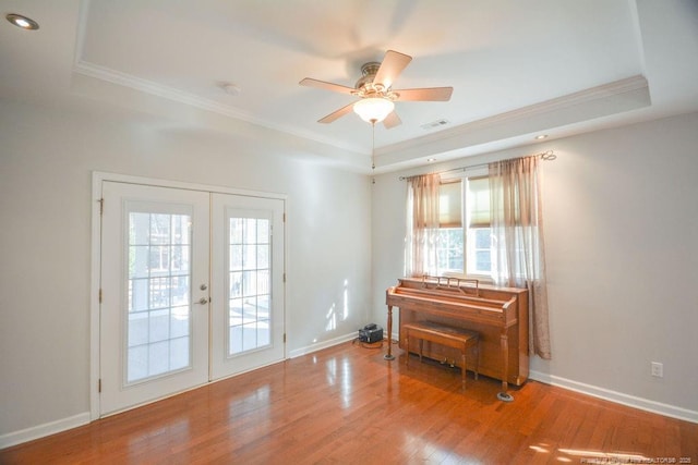 entryway with wood finished floors, french doors, a raised ceiling, and visible vents