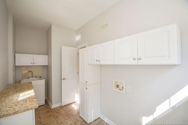 laundry room featuring cabinet space, baseboards, visible vents, hookup for a washing machine, and a sink