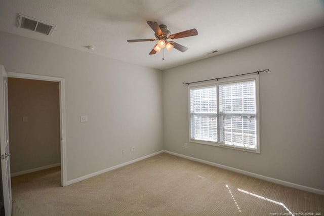 unfurnished room featuring baseboards, visible vents, and light colored carpet