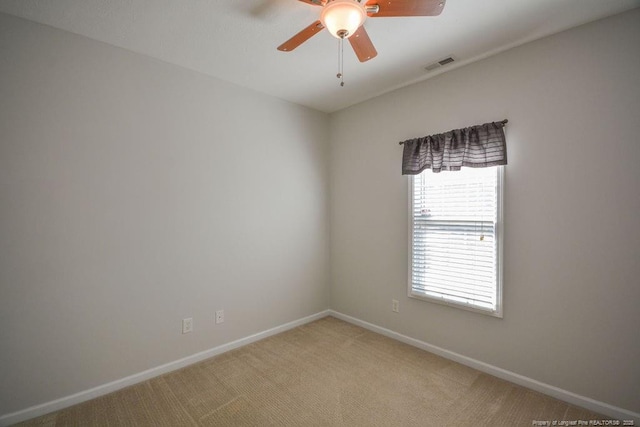 empty room with light carpet, ceiling fan, visible vents, and baseboards