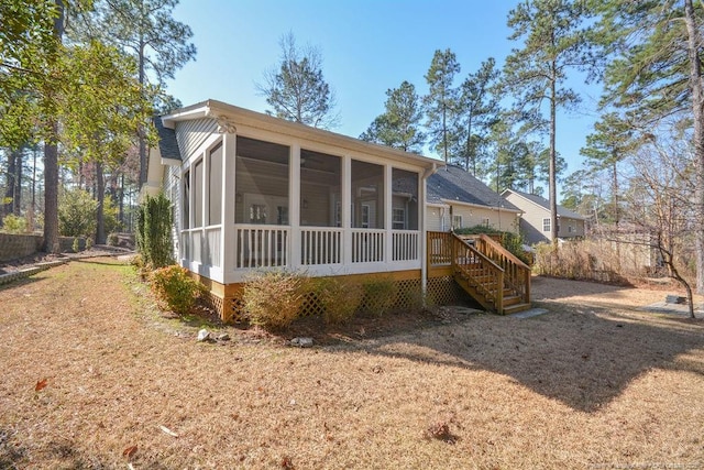 rear view of house featuring a sunroom and stairs