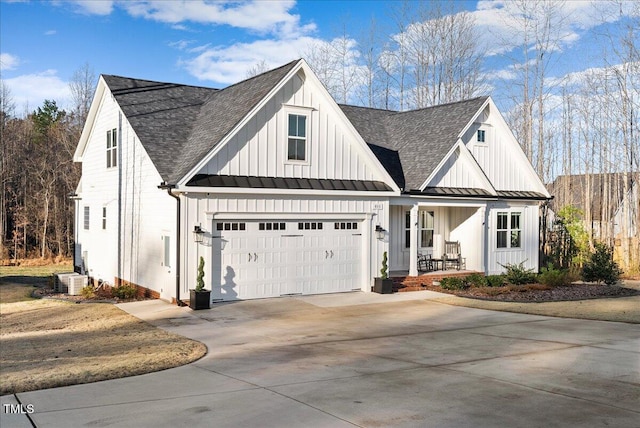 modern farmhouse featuring driveway, covered porch, board and batten siding, and a standing seam roof