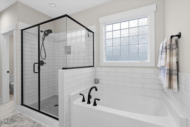 bathroom featuring a shower stall, toilet, and a bath