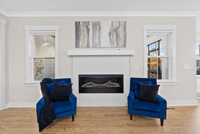 sitting room featuring ornamental molding, a fireplace, baseboards, and wood finished floors