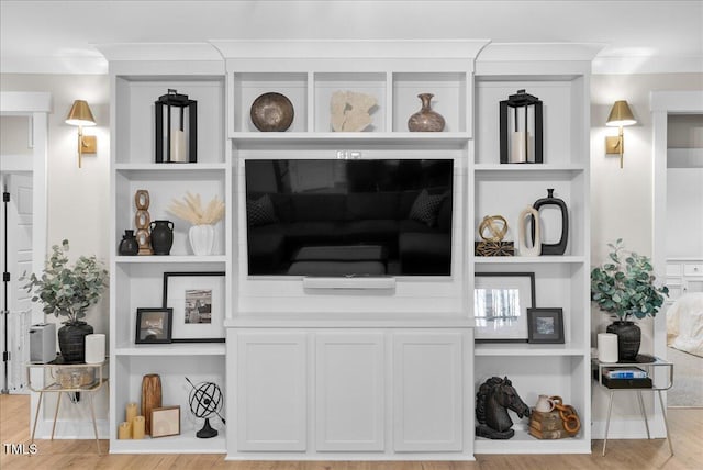 living room with crown molding, built in features, and wood finished floors