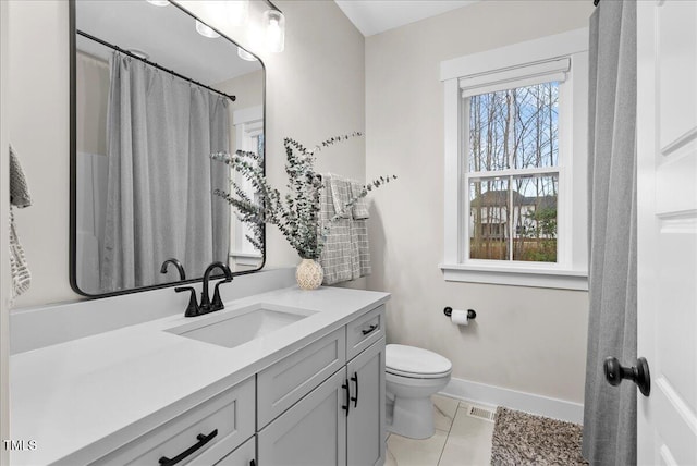 bathroom with toilet, vanity, visible vents, and baseboards