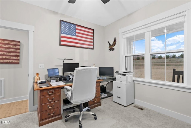 office space with light colored carpet, visible vents, and baseboards