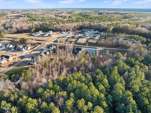 bird's eye view with a wooded view